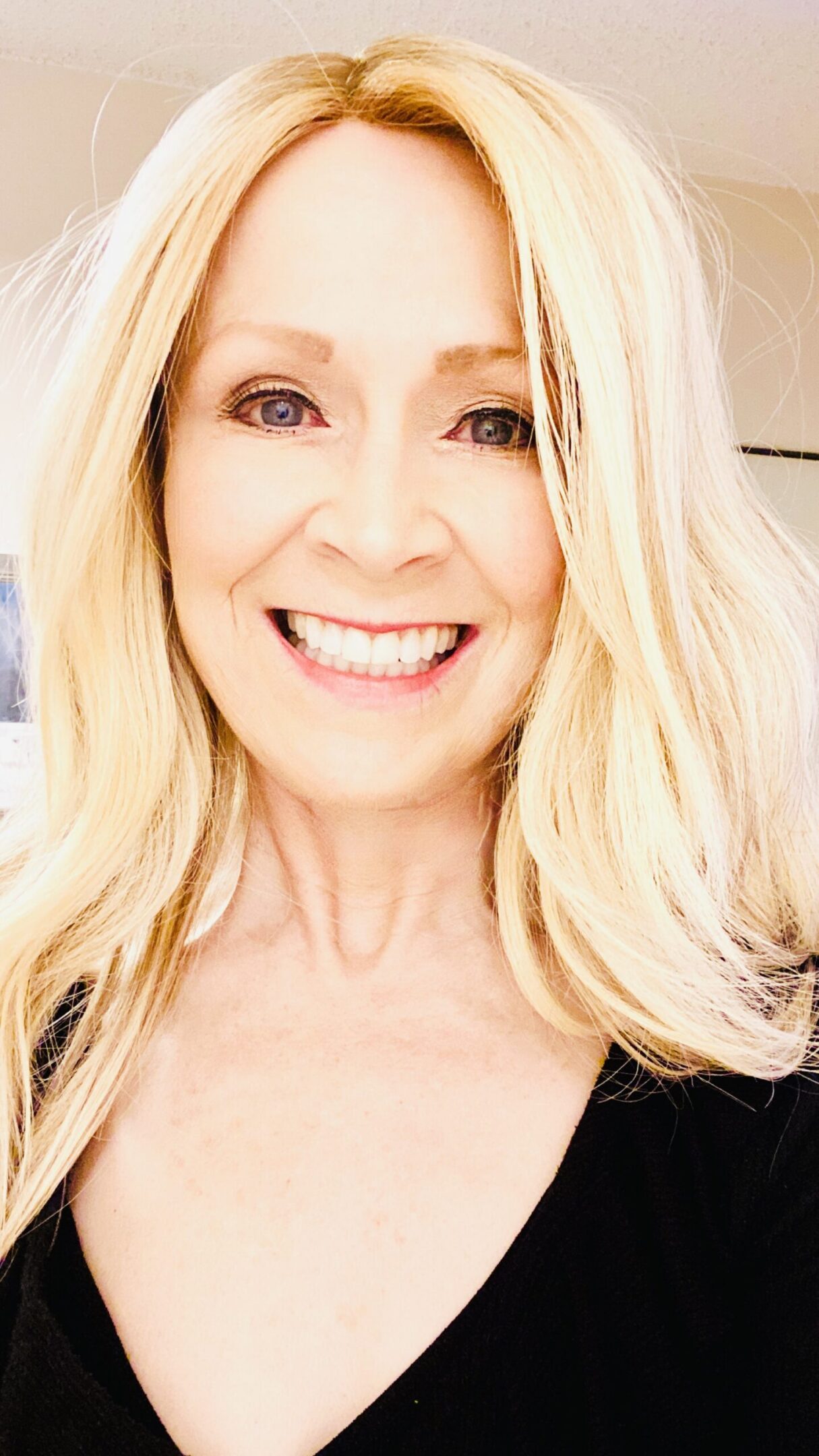 Smiling person with long blonde hair.